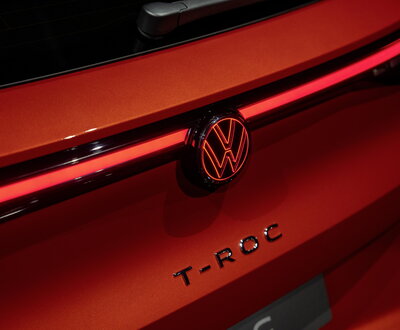 Detail van de achterklep van de rode Volkswagen T-Roc met VW-logo en LED-lichtstrip.